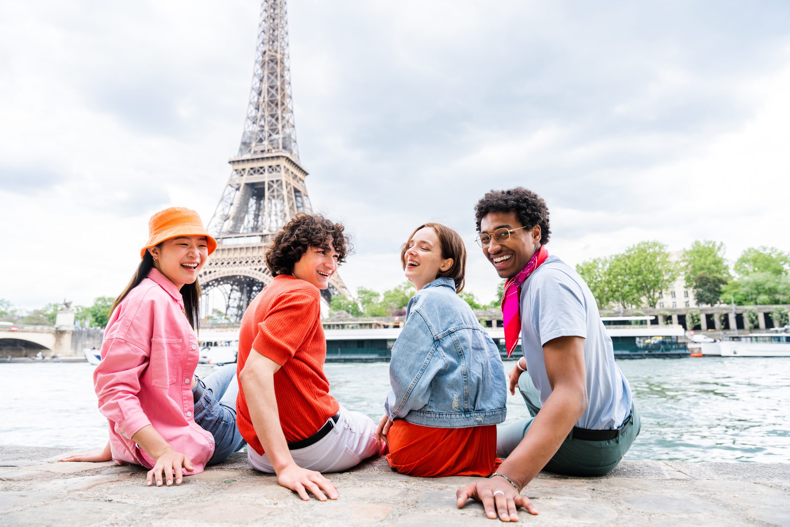 Group of young happy friends visiting Paris and Eiffel Tower, Trocadero area and Seine river - Multicultural group of tourists sightseeing the France capital city